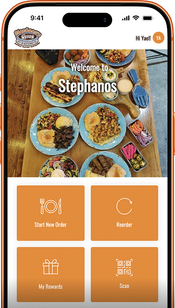 A smartphone displays a food ordering app with "Welcome to Stephanos" over a table of Mediterranean dishes.
