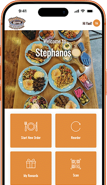 A smartphone displays a food ordering app with "Welcome to Stephanos" over a table of Mediterranean dishes.