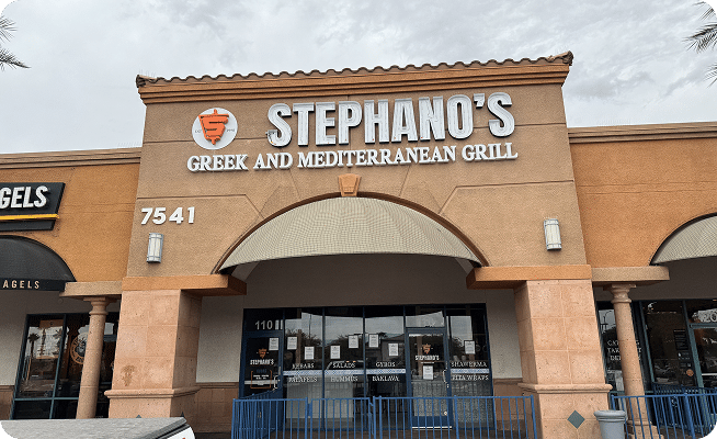 A tan building with "STEPHANO'S GREEK AND MEDITERRANEAN GRILL" in white letters above an arched entrance.